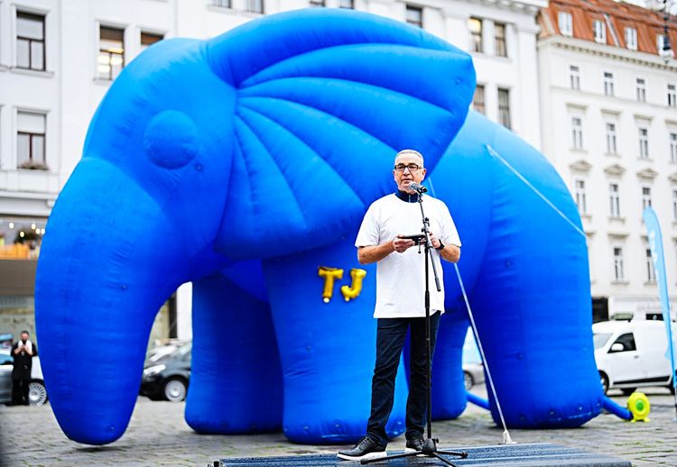 Multimillionär Djaffar Shalchi steht vor einem riesigen aufblasbaren blauen Elefant in Wien.