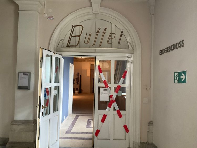 Eingangsbereich des früheren Buffets im Landesgericht für Strafsachen Wien, dessen Türen mit überkreuzten rot-weißen Kunststoffbändern verklebt sind.