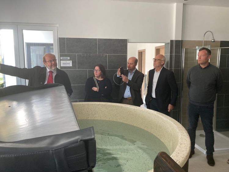 ein mann erklärt anderen männern etwas vor einem whirlpool