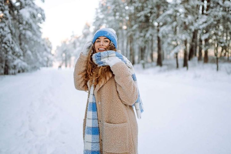 Junge, lachende Frau in Schneelandschaft