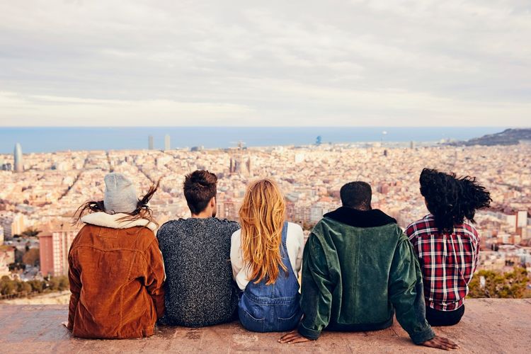 Fünf junge Erwachsene genießen den Ausblick auf eine Großstadt.