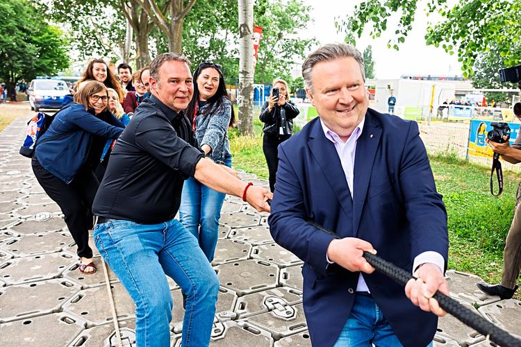 SPÖ-Chef Andreas Babler und Bürgermeister Michael Ludwig (beide SPÖ) versuchen einen Laster in Bewegung zu setzen.