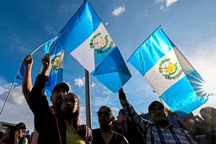Personen schwenken die Nationalflagge Guatemalas