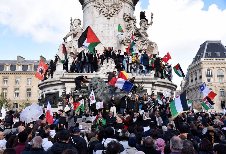Place de la République, Paris. Rund um das Monument à la République Menschen unter anderem mit Palästina-Flaggen