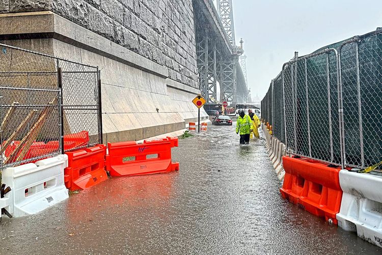 Ersthelfer waten durch das Hochwasser am Fuße der Williamsburg Bridge, die die Lower East Side von Manhattan mit dem Stadtteil Williamsburg verbindet.