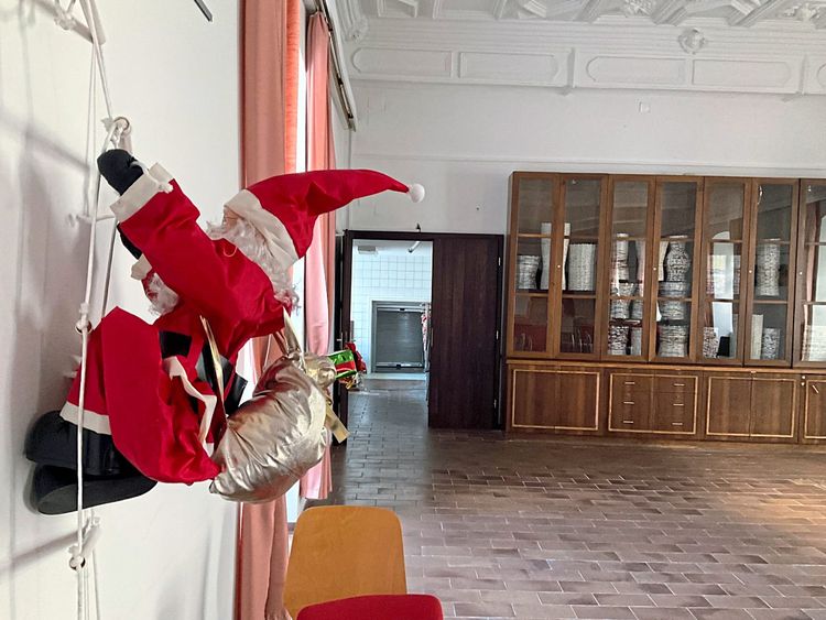 An der Wand des Festsaals der JA Sonnberg klettert ein Weihnachtsmann an der Wand.