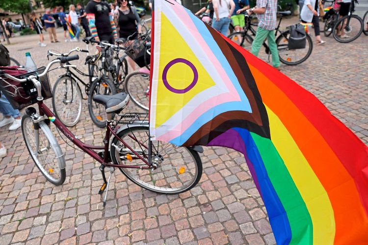 Eine auf dem Fahrrad befestigte Regenbogenfahne. 
