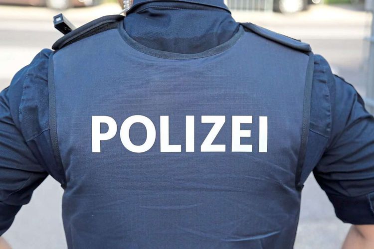 Rückenansicht eines uniformierten Polizeibeamten.