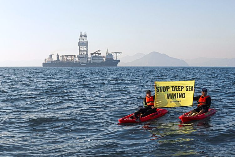 Zwei Aktivisten sitzen in Kanus und protestieren mit einem Schild gegen Tiefseebergbau