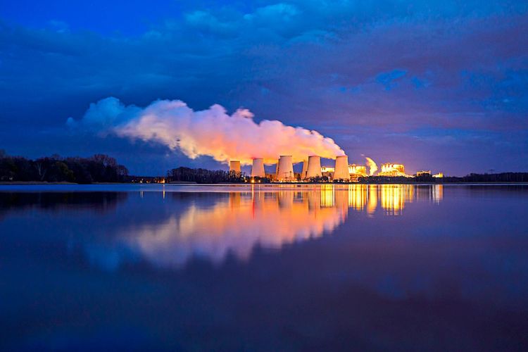 Braunkohlekraftwerk Jaenschwalde im Lausitzer Kohlerevier, Brandenburg im März 2023. Abendaufnahme, in der Ferne Wolken aus Wasserdampf, die aus Kühltürmen kommen