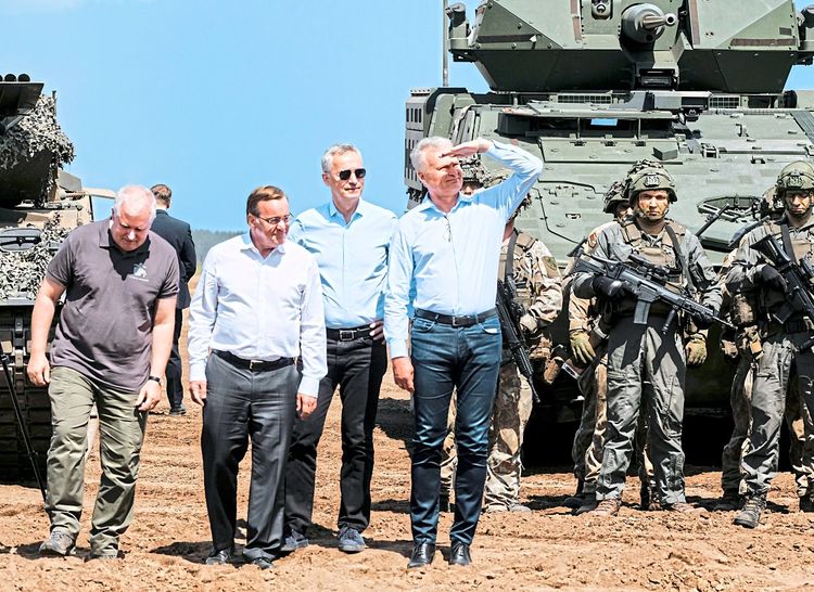 Der litauische Verteidigungsminister Arvydas Anušauskas, sein deutscher Amtskollege Boris Pistorius, Nato-Generalsekretär Jens Stoltenberg und Litauens Präsident Gitanas Nausėda stehen vor Panzern.