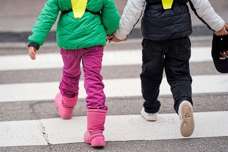 Kindergartenkinder überqueren Straße