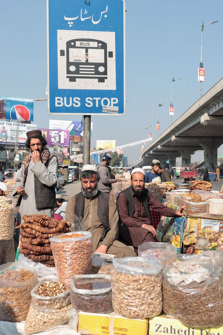 Diese paschtunischen Männer betreiben einen Markt für Trockenfrüchte unter freiem Himmel entlang der Hauptstraße in Gujranwala City, Pakistan, an einer Stelle, die eigentlich eine Bushaltestelle sein sollte. Das Bild wurde an einem hellen, sonnigen Wintertag von Muhammad Saddique Inam (Pakistan) aufgenommen und spiegelt das Leben in der Stadt wider.