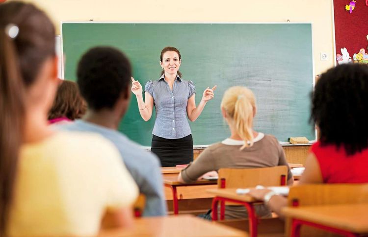 Unterrichtsszene: Eine Lehrerin steht vor einer Schulklasse mit Kindern