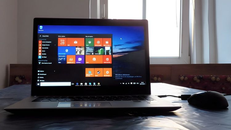 Ein Laptop auf einem Tisch. Am Laptop läuft die erste fertige Version von Windows 10.