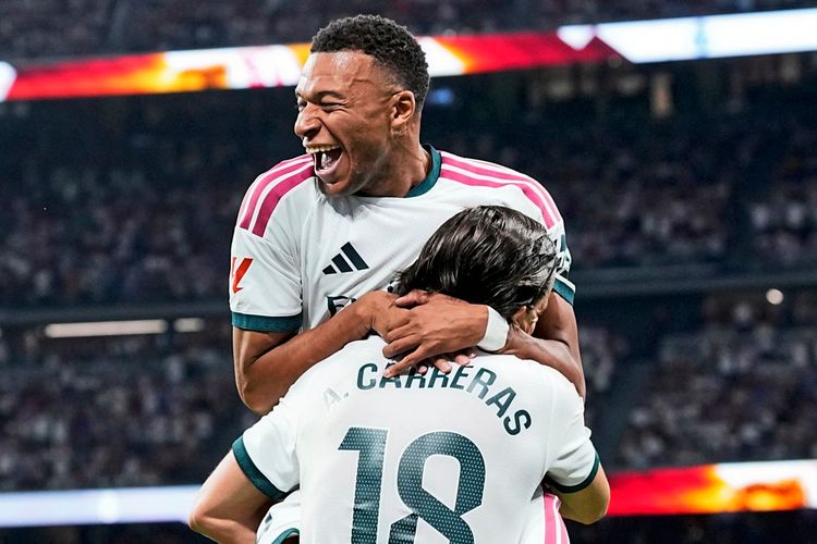 Zwei Fußballspieler von Real Madrid feiern ein Tor während eines Spiels im Bernabéu-Stadion. Einer der Spieler trägt die Nummer 18 und hebt den anderen jubelnd hoch. Im Hintergrund sind Zuschauer und das Spielfeld erkennbar.