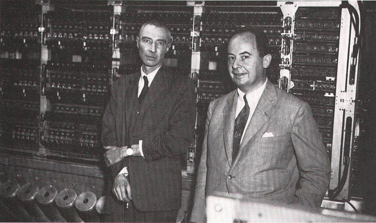 Die zwei Forscher posieren vor einer raumfüllenden Maschine.
