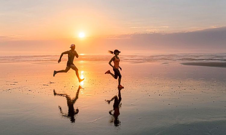 Paar läuft am Strand vor Sonnenuntergang