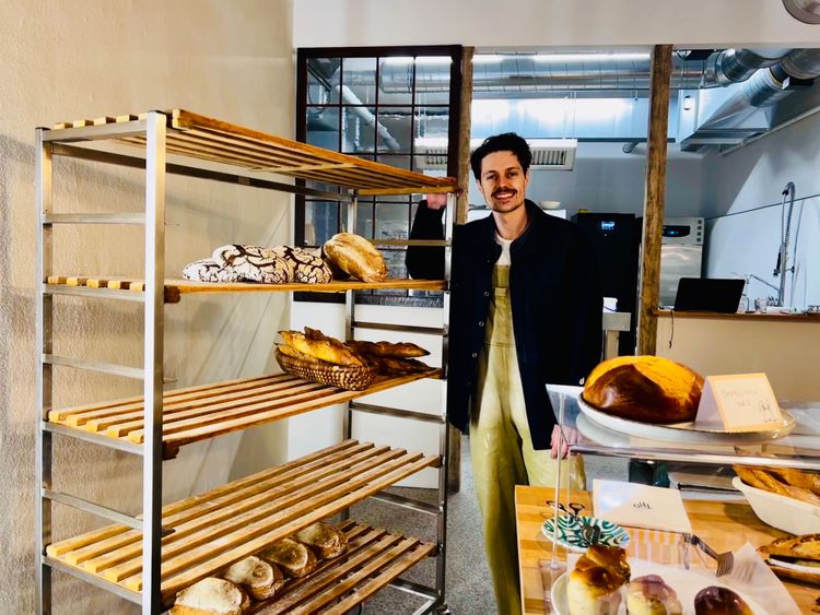 Paul Thomann neben einem Brot-Regal in seiner Bäckerei  