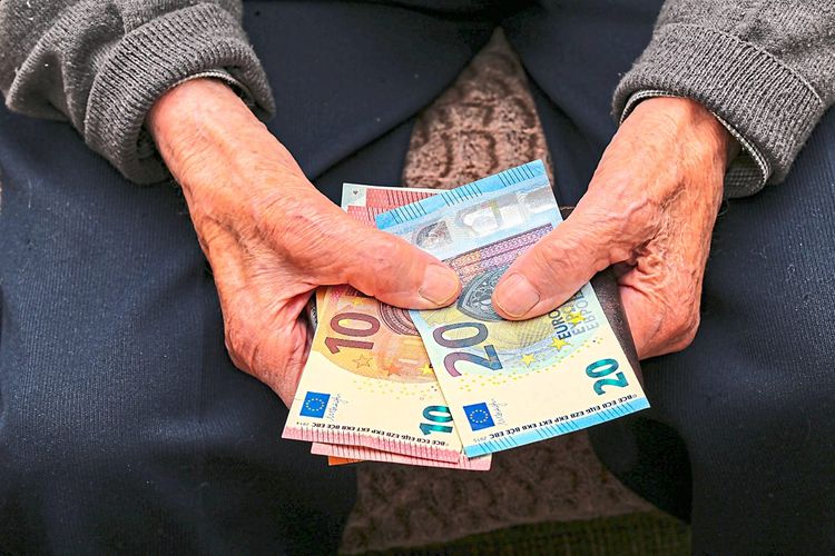 Älterer Mensch mit Geldscheinen in der Hand