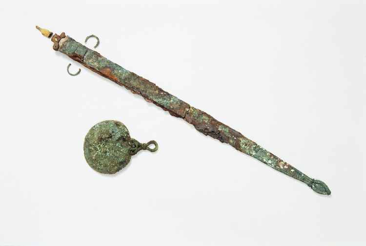 grüne Patina und Rost auf Schwert und Spiegel, archäologischer Fund