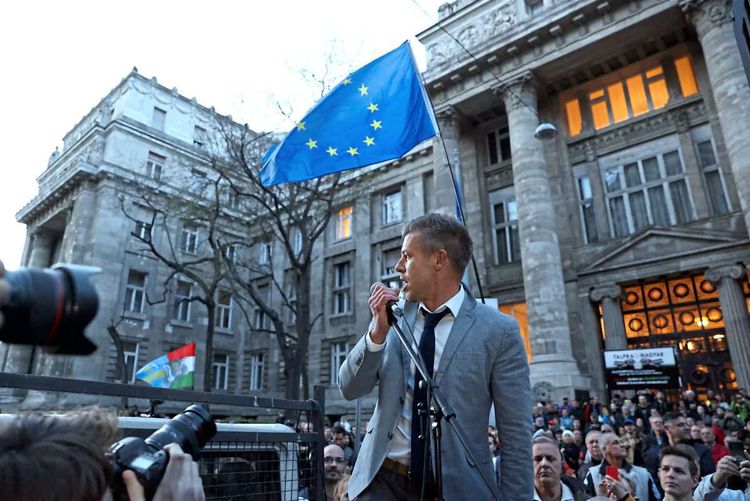 Peter Magyar auf einer Demo in Budapest, im Hintergrund eine große EU-Flagge.