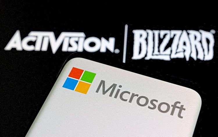 Auf einem Smartphone ist ein Microsoft-Logo zu sehen. Drüber steht der Activision-Blizzard-Schriftzug.