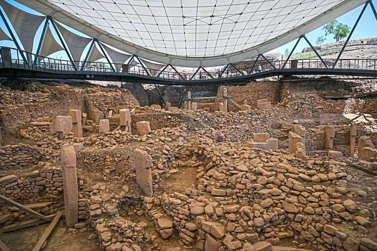 Zur Fundstätte Göbekli Tepe in der Türkei gehört dieser weitläufige Bereich ausgegrabener Steinsäulen und aufeinandergestapelter Steine unter einer modernen Dachkonstruktion zum Schutz der Funde.