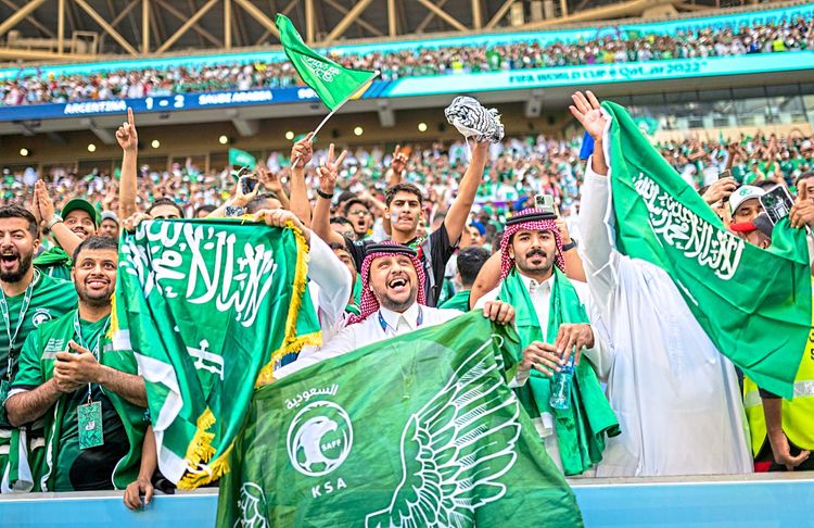 Jubelnde Fans Saudi-Arabiens mit Flaggen bei einem WM-Spiel 2022.