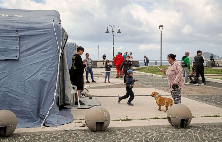 Menschen stehen vor Zelten