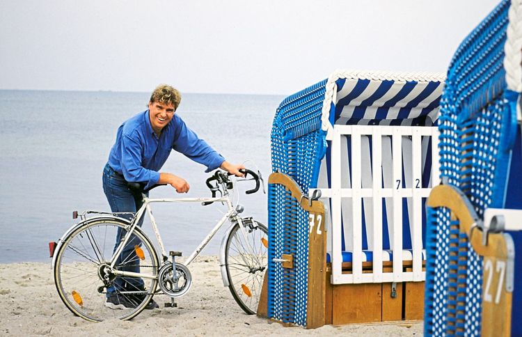 Frank Schöbel mit Fahrrad vor einem Strandkorb