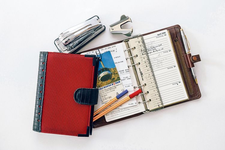 Ein Taschenkalender und ein Notizbuch, eine Heftmaschine und ein Klammerentferner