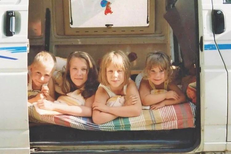 Ein altes Bild von vier Kindern in einem Campingbus