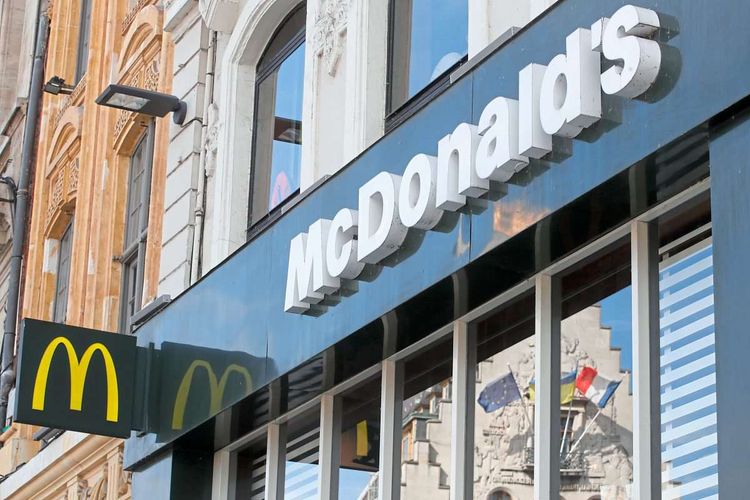 Der Eingang einer Filiale von McDonald's. Zu sehen ist ein Schild mit dem Logo und der Schriftzug von McDonalds.