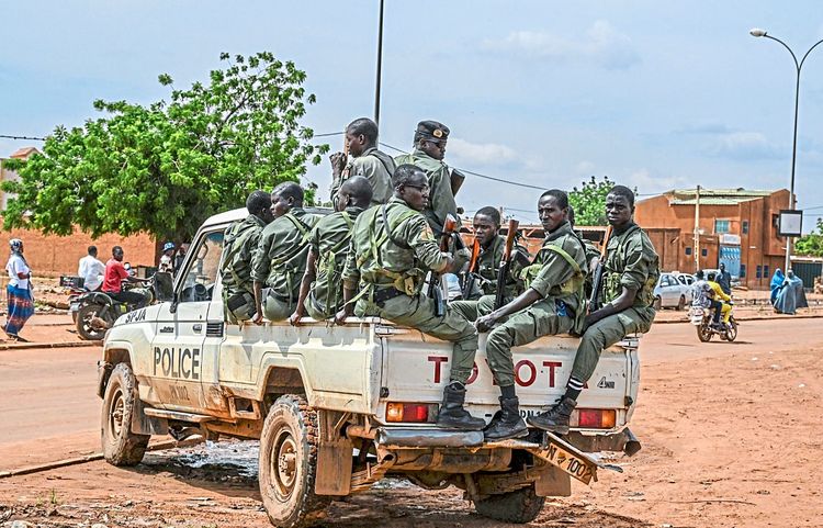Mehrere Polizisten hocken auf einem Jeep in Niamey.