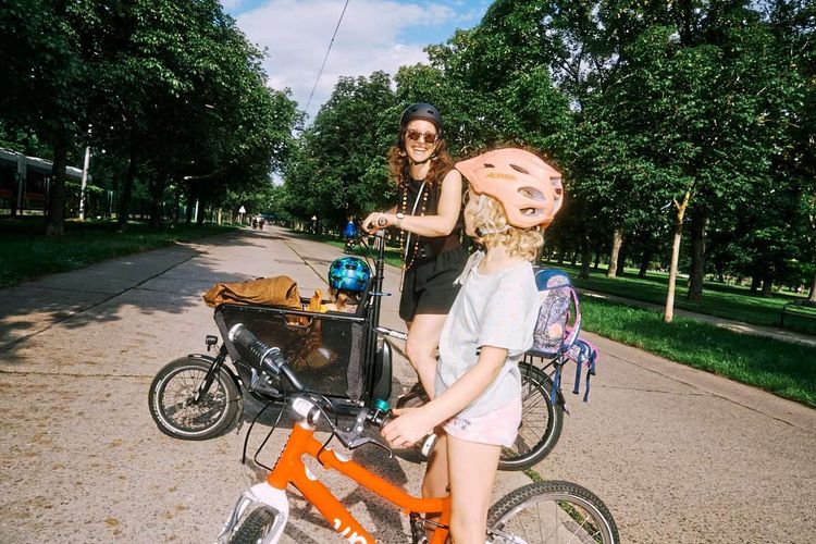 Elli und ihre zwei Töchtern auf den Fahrrädern am Weg in die Schule