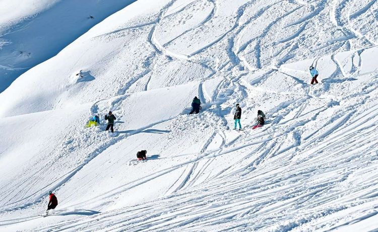 Menschen auf Snowboard- und Skipiste im Schnee