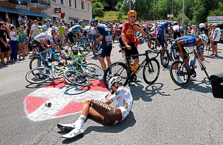 Das Bild stammt vom Massensturz der 15. Etappe. Zwei Fahrer und Räder liegen am Boden. Andere Fahrer bringen ihr Rad wieder auf Vordermann.