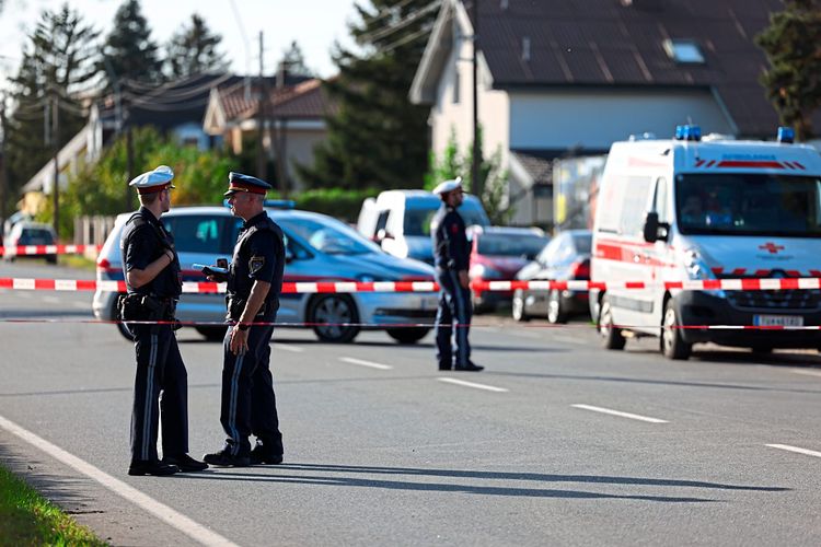 Polizisten hinter Absperrung bei Tatort in Strasshof