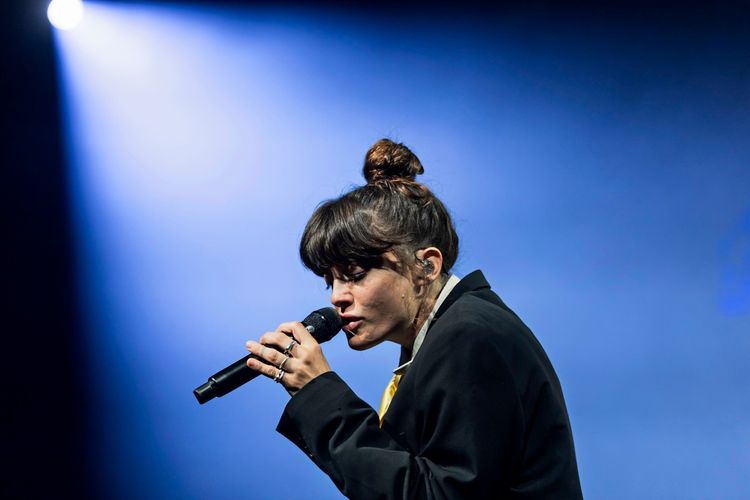 Israeliische Musikerin tritt während des Montreux Jazz Festivals 2026 auf einer Bühne auf. Sie hält ein Mikrofon und singt, im Hintergrund ist blaues Bühnenlicht zu sehen.