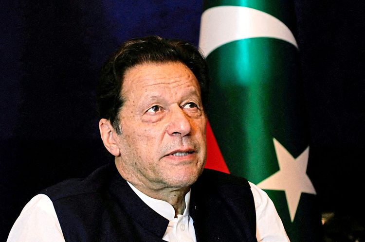Imran Khan ist zu sehen. Im Hintergrund ist die pakistanische Flagge zu sehen.