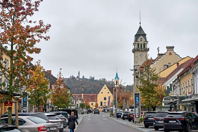 Der Hauptplatz von Leibnitz, links und rechts parken Autos, alles ist asphaltiert.