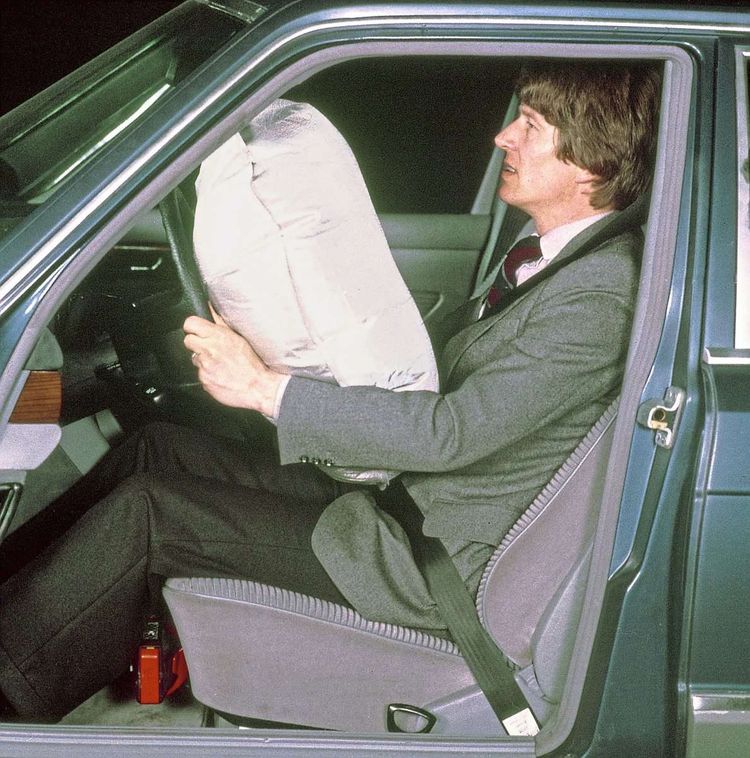 Ein Mann in einem Auto mit aufgeblasenem Airbag