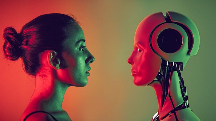 Eine Frau sieht einen Roboter mit menschlichen Zügen aufmerksam an.