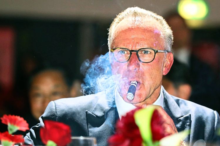 Karl-Heinz Rummenigge raucht eine Zigarre.