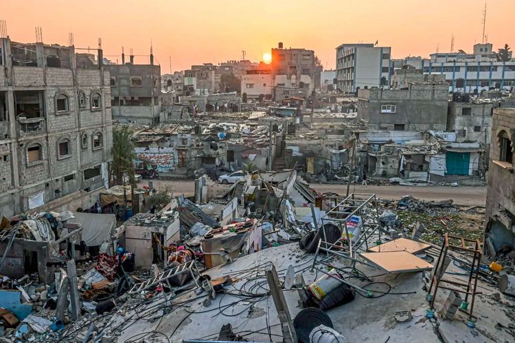Die Sonne geht über zerstörten Häusern im Gazastreifen auf.
