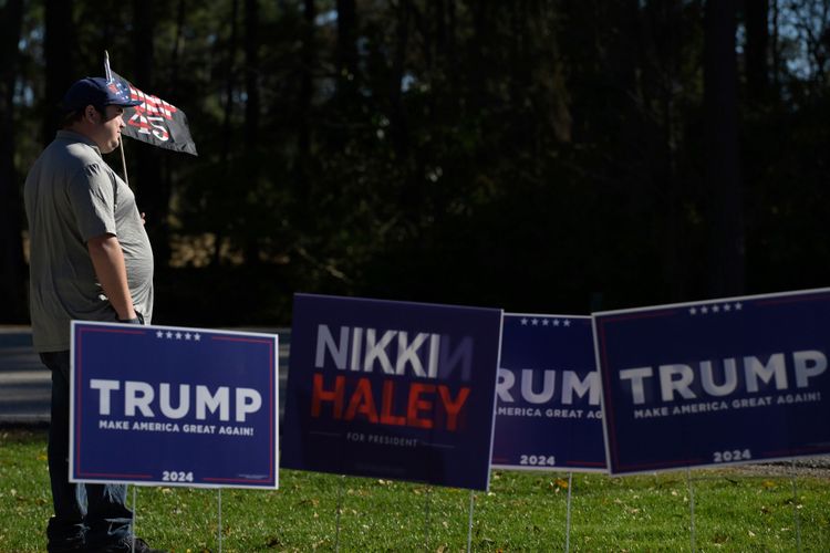 Trump-Unterstützer hält ein Plakat, daneben eines der republikanischen Kandidatin Haley