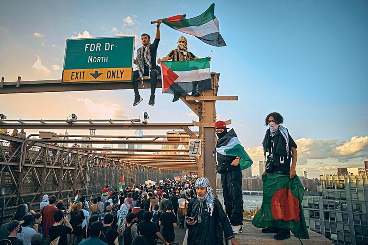 Pro-Palästina-Demonstranten ziehen über die Brooklyn-Brücke in New York. Ein paar Demonstranten sind auch das Geländer der Brücke geklettert. 