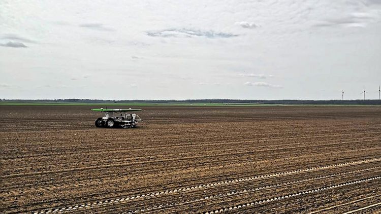 Feldroboter, angetrieben von Solarpanelen beackert ein Feld
