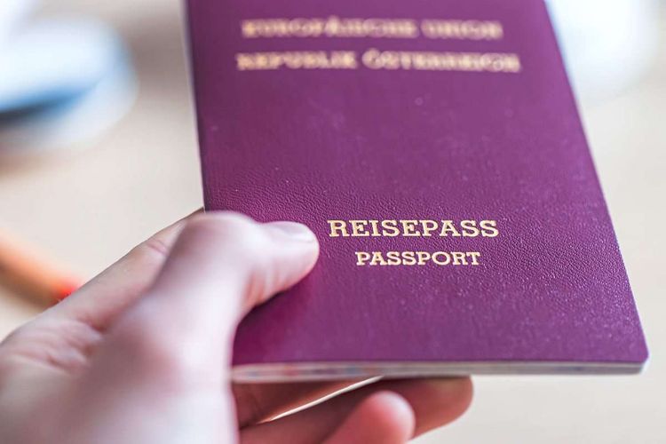 Hand hält einen österreichischen Reisepass